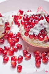 ripe cuting pomegranate at plate around white background