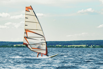 Windsurfer catches the wind and cuts the waves while driving fast