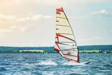 Windsurfer catches the wind and cuts the waves while driving fast