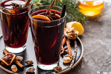 Hot mulled wine with spices, apple and orange on chrictmas background. Copy space.