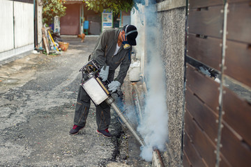 Man spraying fogging, eliminating mosquitoes, stopping the spread of dengue fever