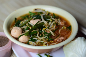 noodle soup with chopsticks in bowl on a wooden table,Thailand style
