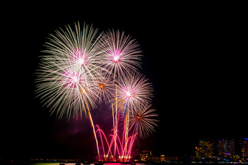Naklejka premium Beautiful colorful fireworks display on the sea beach, Amazing holiday fireworks party or any celebration event in the dark sky.
