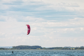 A kiteboarder is pulled across water by a power kite