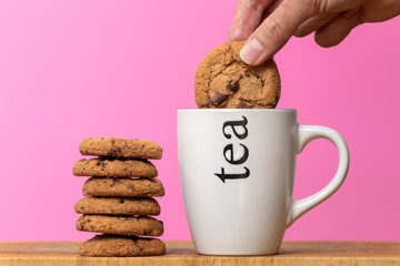 dunking a biscuit in a mug of tea