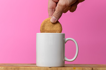dunking a biscuit in a mug of tea