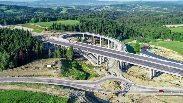 New highway under construction in Poland on national road no 7, E77, called Zakopianka.  Overpass crossroad with traffic circles and viaducts near Naprawa village. Aerial video