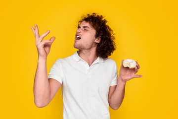 Young man tasting yummy doughnut
