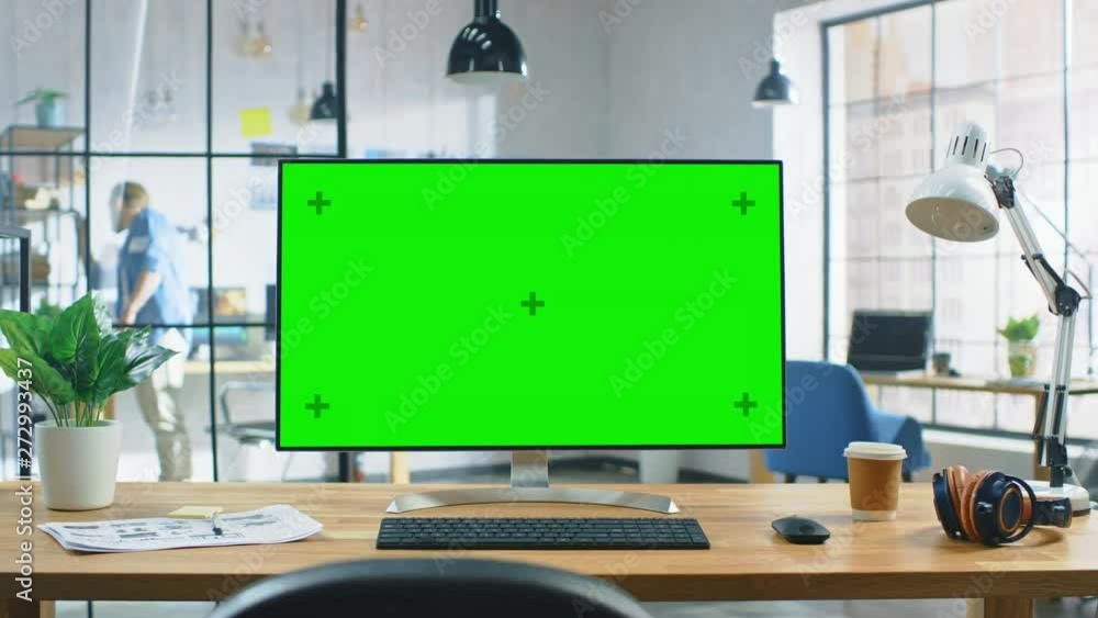Poster Wide Green Mock-up Screen Desktop Computer Standing on the Desk in the Modern Creative Office. In the Background Bright Creative Loft for Developers and Designers where Professional Working