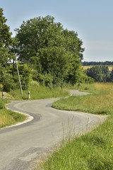 Fototapeta na wymiar Zing-zags à une route de campagne près du bourg de Fontaine au Périgord Vert
