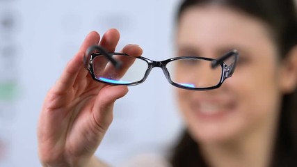 Cheerful woman proposing eyeglasses, patient recommendation, vision support