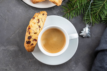 Traditional Christmas pastries, Italian homemade double-baked biscotti or cantuccini cakewith coffee, with nuts and dried fruits. with xmas decorations and fir branches.