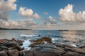 The waves break on the rocks at sunset.