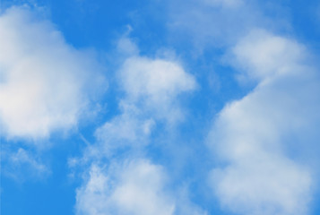 Summer background with white flying clouds on blue sky. Romantic natural heaven backdrop.