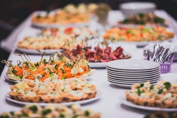 Beautifully decorated catering banquet table with different food snacks and appetizers on corporate, christmas, birthday party event or wedding celebration