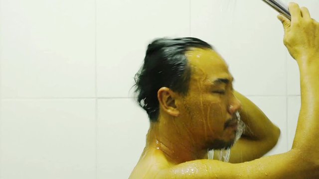 The Side Faces Of Asian Men Wet Water From The Shower And Hand Washing Hair  Within The Bathroom.