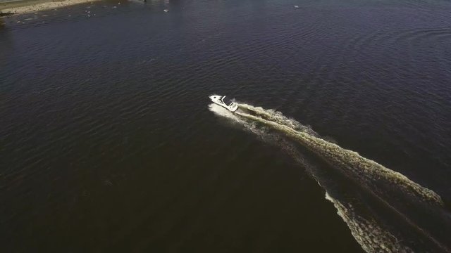 Aerial view of motor boats sailing on the river. Top down view of motorboat doing circles and leaving white foam tracks on the river. 4k shot drone  