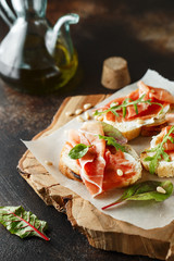 Traditional parma cured ham antipasto. Bruschetta set with Parma Ham and Parmesan Cheese. Small...