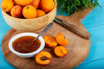 Apricot jam and fresh apricots in wood bowl. 
