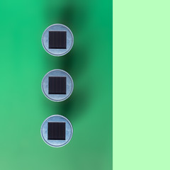 three LED solar panels from above with green background