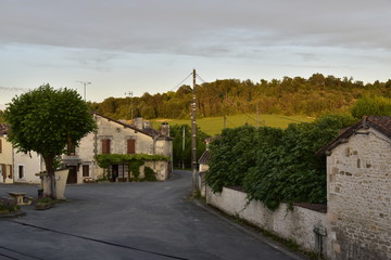 Lumière du coucher de soleil sur les maisons ,bois et champs à Champagne ,au Périgord Vert