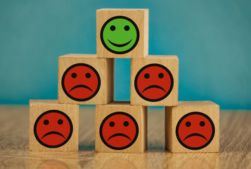smiling and sad emoticons on a blue background. satisfaction concept