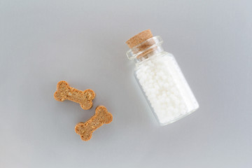 homeopathic globules for animal in a glass bottle and treats like bones