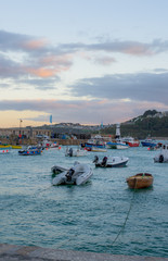 St Ives City during sunset. St Ives is a seaside town, civil parish and port in Cornwall, UK. The town lies north of Penzance and west of Camborne on the coast of the Celtic Sea