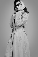 Young elegant brunette woman in coat and shawl posing in studio