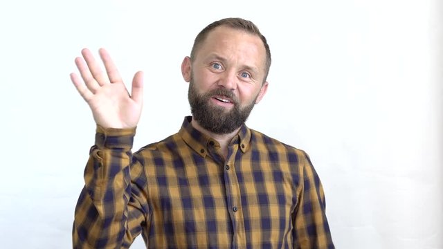 concept of emotions and feelings that we experience when dealing with people. close-up of an attractive bearded man in a plaid shirt on a white background showing