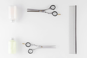 hair care equipment, shampoo and conditioner with comb and scissors on white