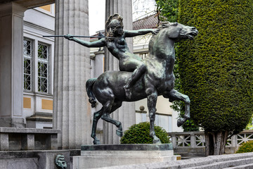 Germany, Munich, Bogenhausen: Equestrian statue with Amazone on horse in front of famous Villa...