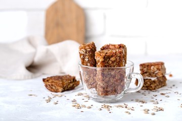 fruit nut bars in glass, transparent cup, useful components, for healthy concept. Light background