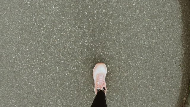 Woman runs on a park alley (slow motion) Top view. POV