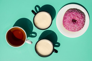 Top view cups of coffee with doghnut