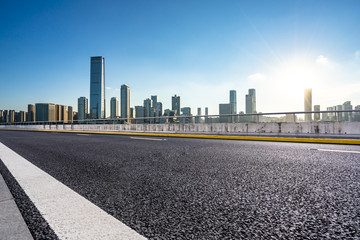 empty raod with city skyline