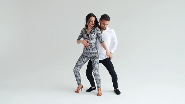 Concept of love, relationships and social dancing. Young beautiful couple dancing sensual dance on a white background