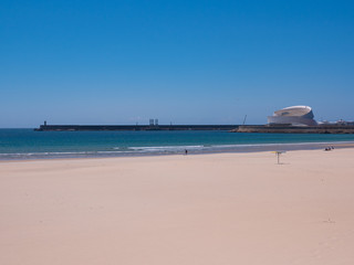 View over Matosinhos beach in Porto, Portugal towards port with lighthouse and Cruise Terminal