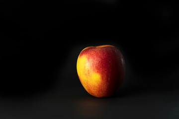 organic yellow red apple fruit on black background