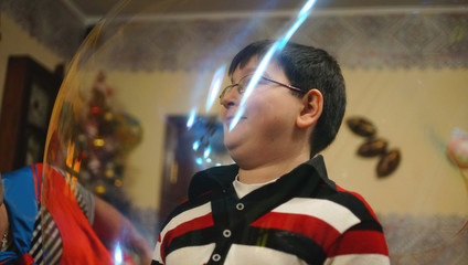Magician put the giant soap bubble on the boy in a cafe