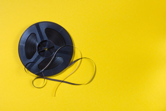 reel-to-reel tape in spool on a yellow background