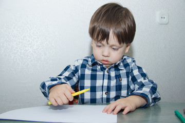 The boy draws felt-tip pens on paper. Drawing. Little boy. Children's drawing. Developmental activities.