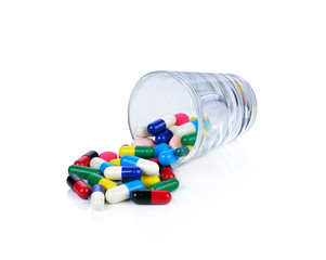 Colored pills, tablets and capsules on a white background