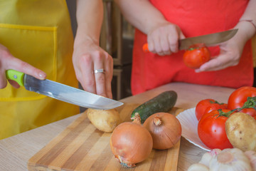 woman hands cutting vegetables on kitchen blackboard. Healthy food. Woman preparing vegetables, cooking healthy meal in the kitchen