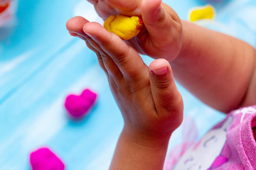 improving fine motor skills educational games concept, modeling soft clay plasticine children's hands close-up blue background