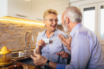 Modern senior couple shopping online with tablet and credit card