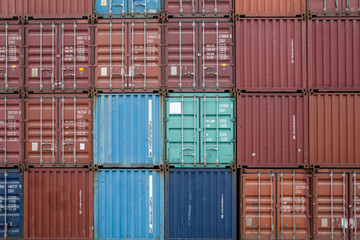 Fototapeta premium Side view of different color of cargo containers stacked together