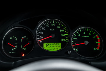 Fototapeta premium Interior view of car with black salon. Modern luxury prestige car interior: speedometer, dashboard and tachometer with green backlight and other buttons. Soft focus