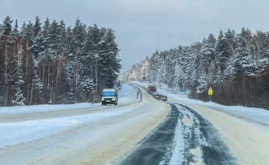 Obraz premium Mari EL region, Russia - December, 29 2014: trucks climb uphill the winter forest road