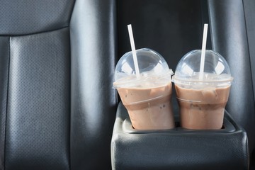 CCold chocolate in a clear plastic cup, two glasses placed in the glass holder in the car